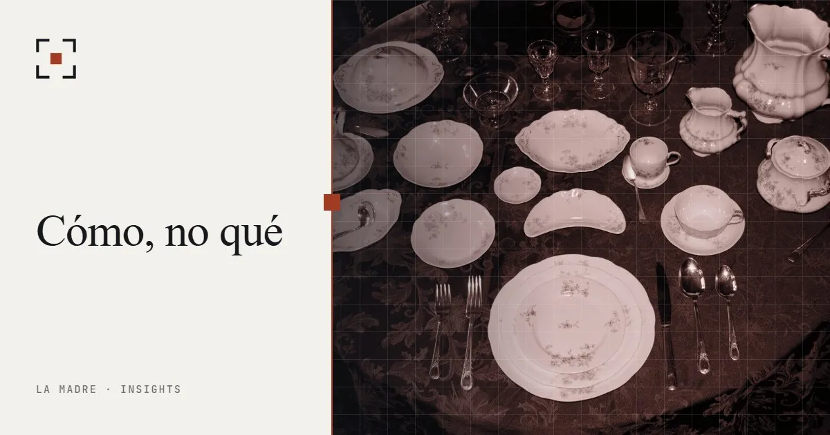 Un servicio de porcelana formal dispuesto sobre un mantel oscuro, en duotono La Madre, junto a las palabras Cómo, no qué