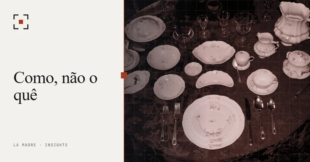 Um serviço de porcelana formal arrumado sobre uma toalha escura, em duotone La Madre, ao lado das palavras Como, não o quê
