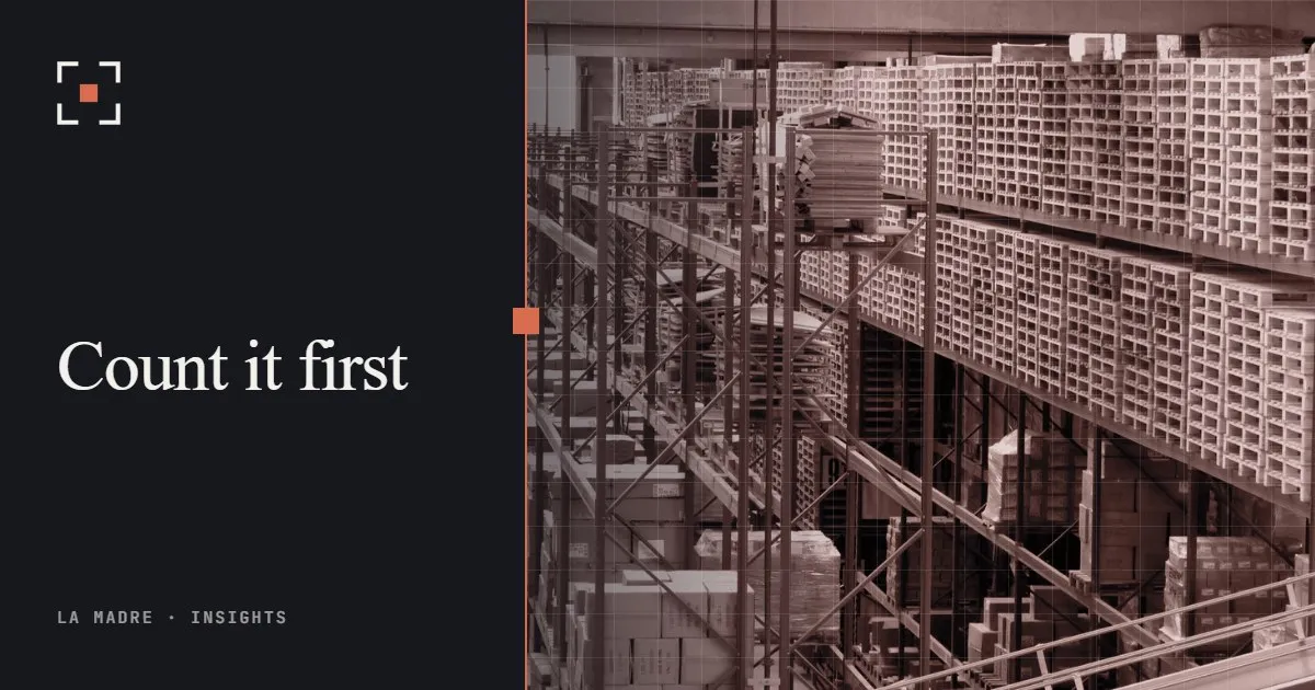 Tall warehouse racks stacked with boxes and pallets, in La Madre duotone, beside the words Count it first
