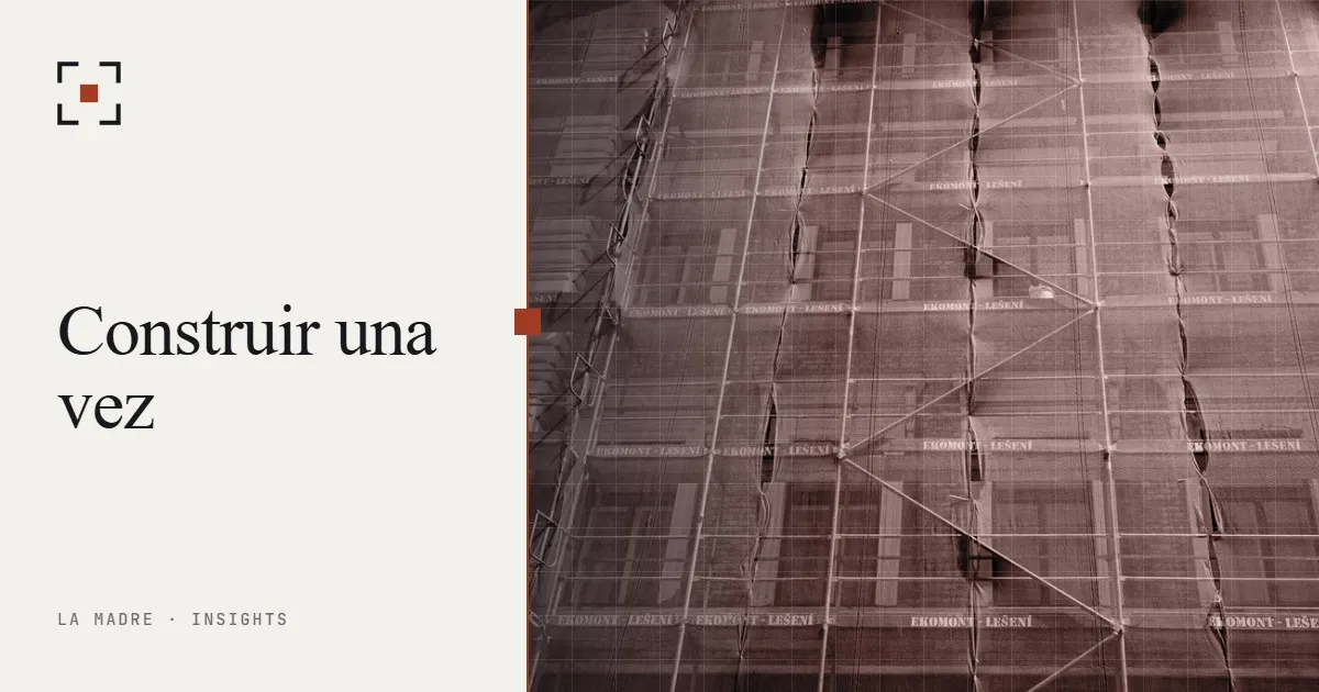 Andamio de obra cubierto con malla, en duotono La Madre, junto a las palabras Construir una vez