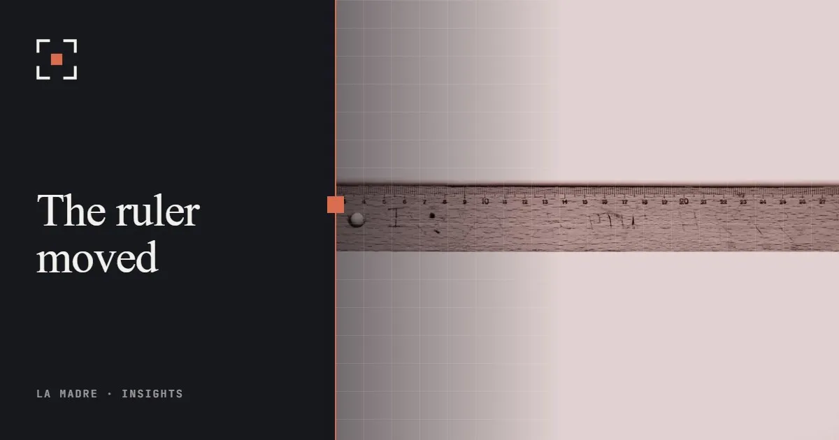 An old wooden ruler on a white surface, in La Madre duotone, beside the words The ruler moved