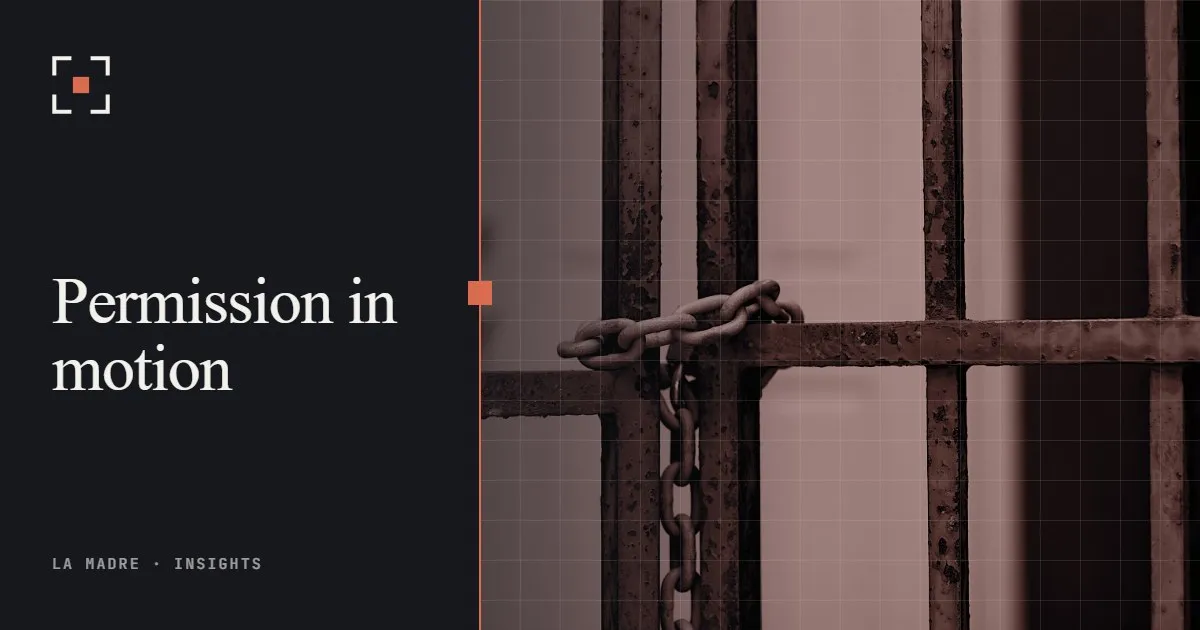 A rusted iron gate held shut with a chain, in La Madre duotone, beside the words Permission in motion