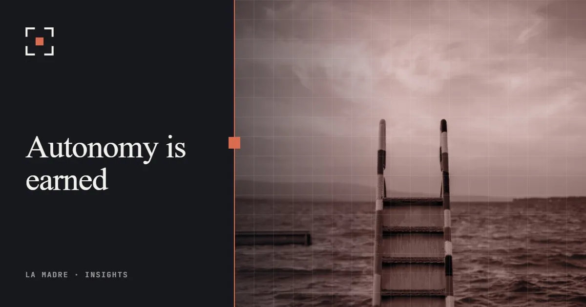 A metal ladder descending into calm sea water at dusk, in La Madre duotone, beside the words Autonomy is earned