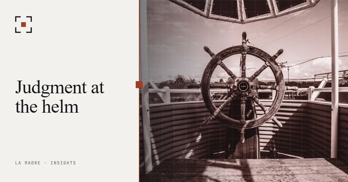 A ship's wooden steering wheel facing the open sea, in La Madre duotone, beside the words Judgment at the helm