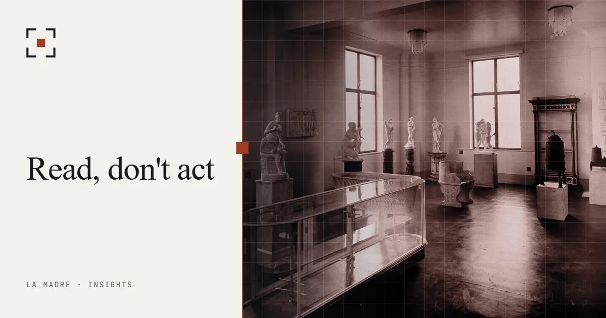 A glass display case in an empty gallery, in La Madre duotone, beside the words Read, don't act