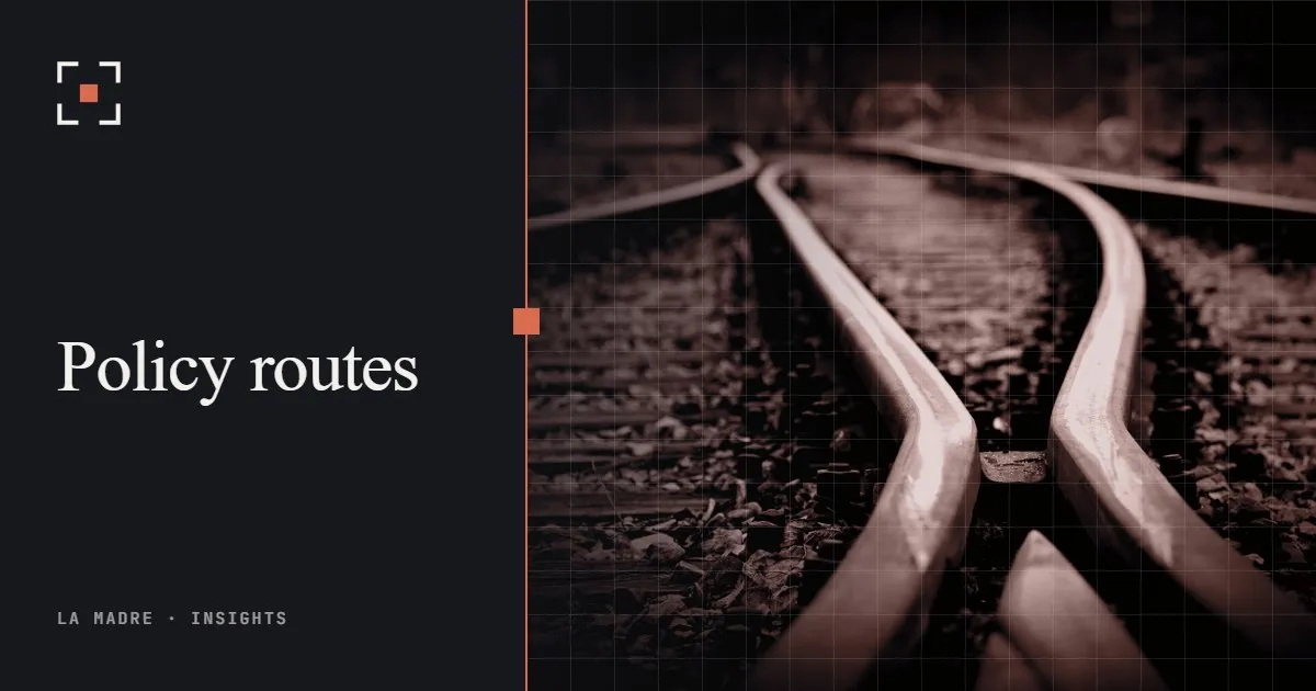 A railway switch where tracks split in two directions, in La Madre duotone, beside the words Policy routes