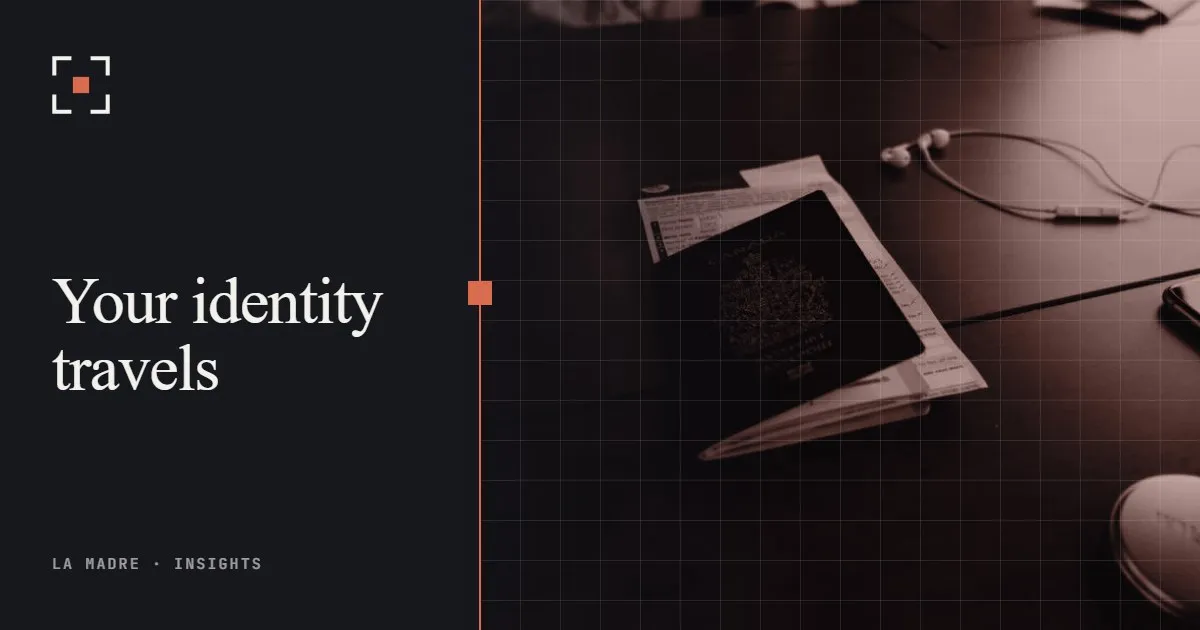 A passport on a dark desk, in La Madre duotone, beside the words Your identity travels